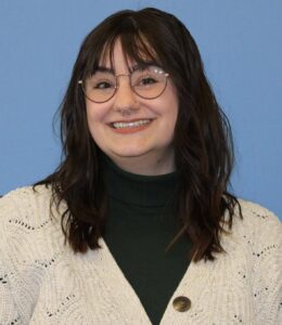 headshot of smiling, female staff member, Allison Pettitt with long dark hair and glasses