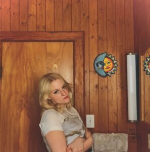 Student poet Irelyn Curry leaning against wooden door in house