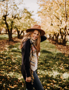 Student poet Lydia Hofmann outside in Fall with hat