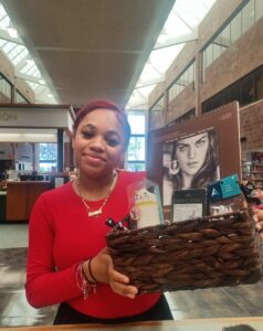 Student Ameenah Perez holding the basket with art supplies that she won