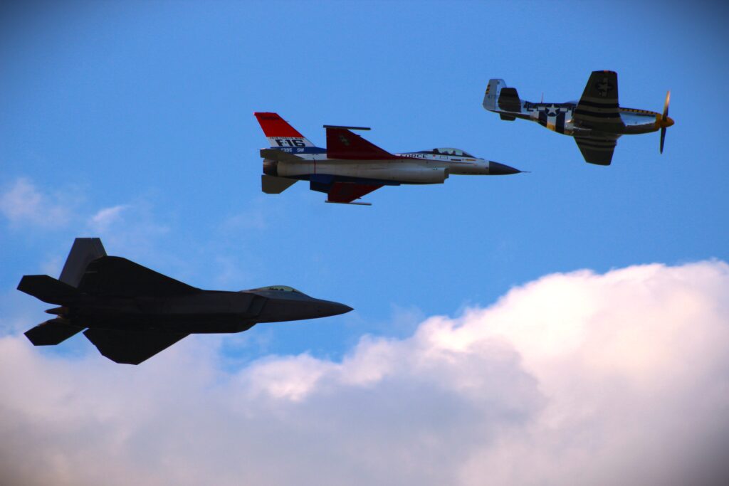 three airplanes flying together with blue sky and clouds in background