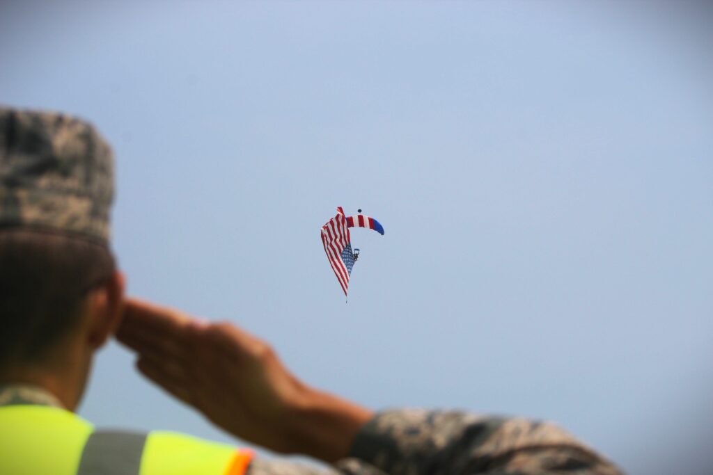 Officer saluting American flag in the sky