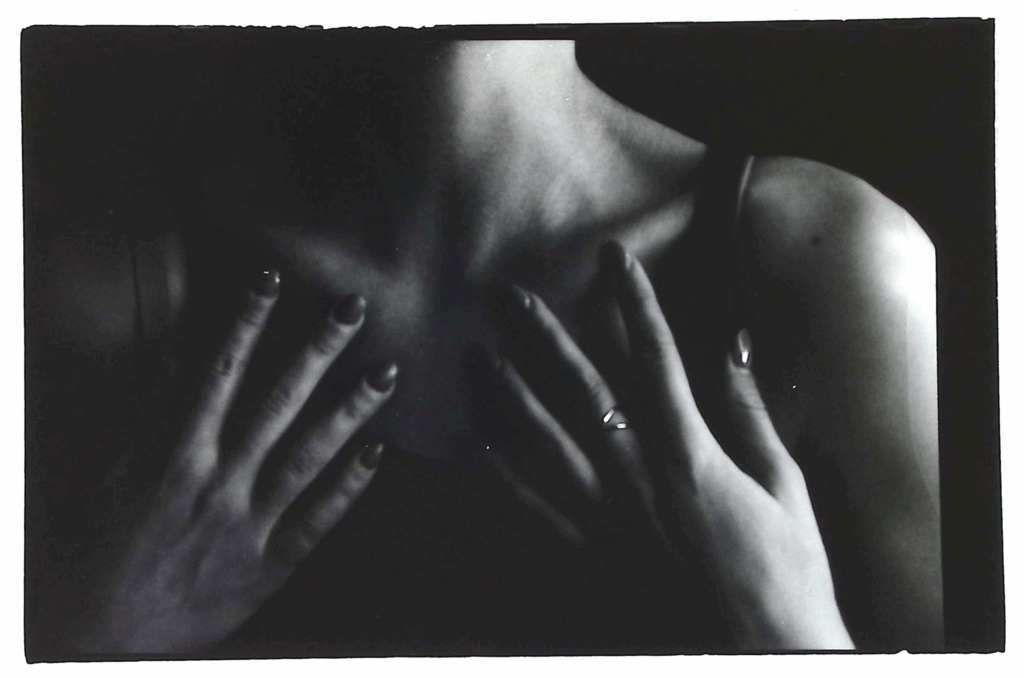 black and white photo of woman with hands on chest