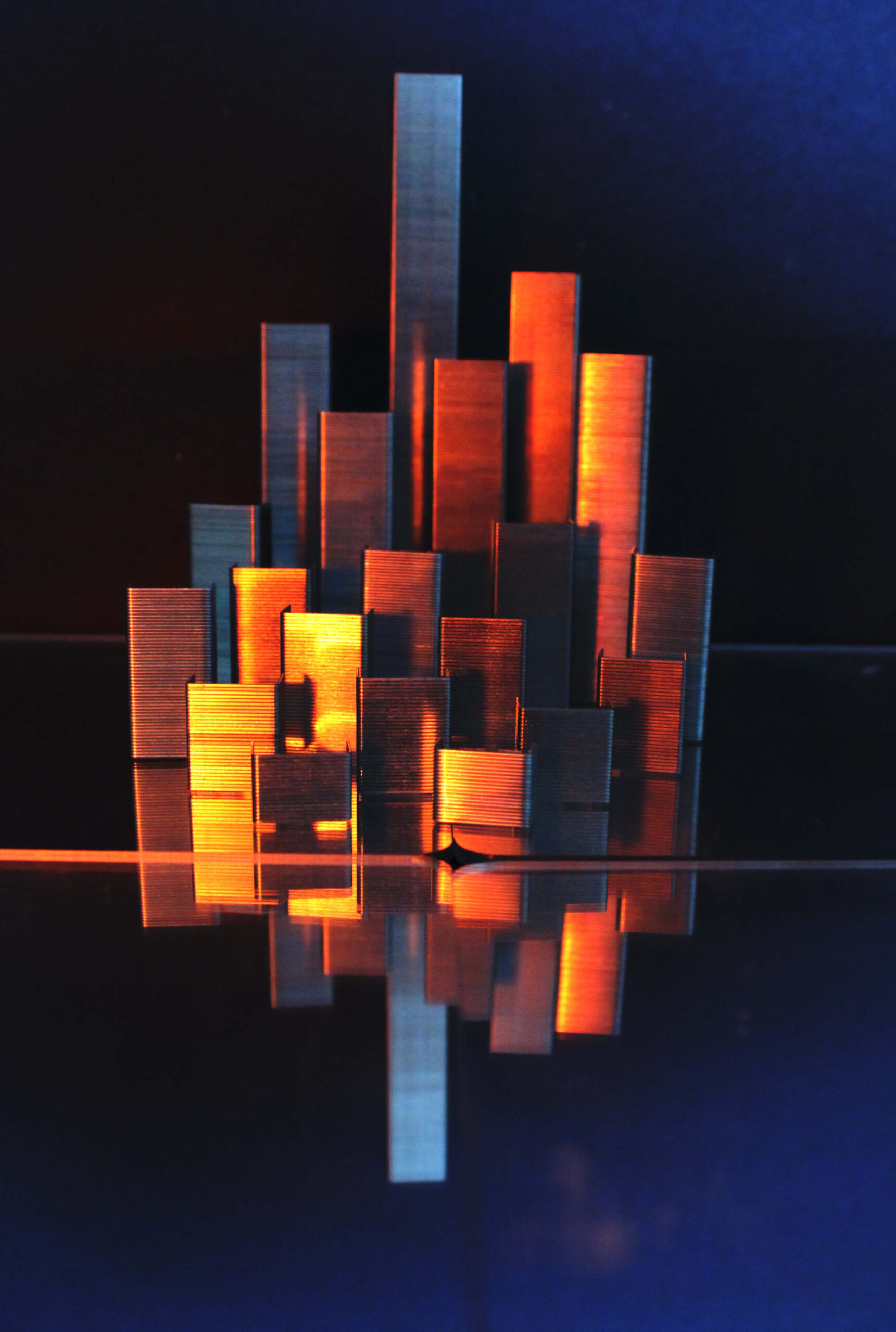 image of stacked staples on a reflective surface resembling a cityscape